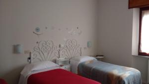 a hospital room with two beds and a window at Hotel Signorini in Castiglioncello