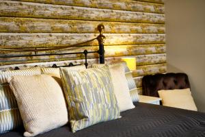 a bedroom with a wooden wall and a bed with pillows at The Westleton Crown in Westleton