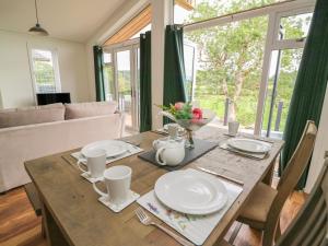 - une table à manger avec des assiettes et des fleurs dans l'établissement Ash Lodge, à Llanidloes