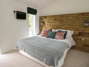 1 dormitorio con 1 cama con pared de madera en Ash Lodge, en Llanidloes