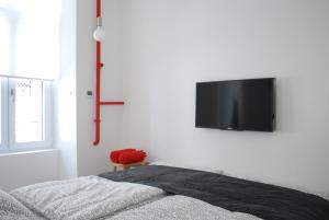 a bedroom with a flat screen tv on a white wall at Stylish Studios Apartment in the City Center with Air Conditioning in Budapest