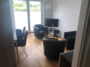 Zimmer mit Stühlen, einem Tisch und einem TV in der Unterkunft Familienfreundliches Ferienhaus Bahnstr 30C in Mainz