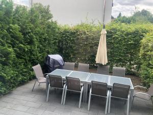 Familienfreundliches Ferienhaus Bahnstr 30C في ماينز: طاولة مع كراسي ومظلة على الفناء