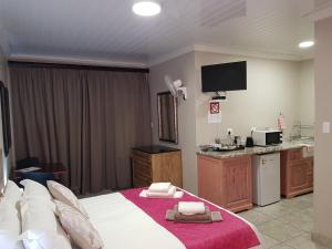 a hotel room with a bed and a kitchen at Huis van Seisoene in Klerksdorp