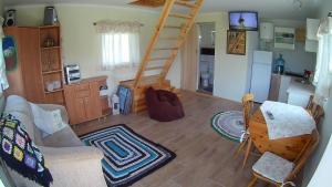 een woonkamer met een ladder en een keuken bij Noclegi Pod Dachem pokoje gościnne domek letniskowy na wynajem agroturystyka wakacje in Sajzy