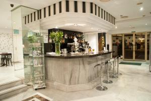 a lobby with a bar with stools in a building at Hotel El Faro Marbella in Marbella