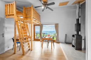 Cette chambre comprend un lit en mezzanine avec une table et des chaises. dans l'établissement Apartmány Chata Jedlová hora, à Jiřetín pod Jedlovou