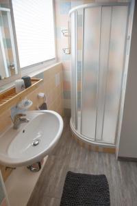 a bathroom with a sink and a shower at Apartment Nobl plac in Celje