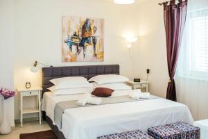1 dormitorio con 1 cama blanca grande y 2 sillas en Mandalina HR Luxury Villa with Private Pool, Tennis Court and Boccie Alley, en Donji Proložac 39 fotos más