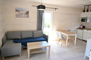 a living room with a couch and a table at Przystań Dziwnówek in Dziwnówek