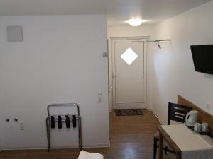 Zimmer mit einer Tür und einem Zimmer mit einem Tisch in der Unterkunft Gästehaus und Fewo Lamm Garni in Blaubeuren