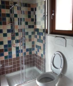 een badkamer met een douche, een toilet en een bad bij Sa Domu e Crakeras in Oristano