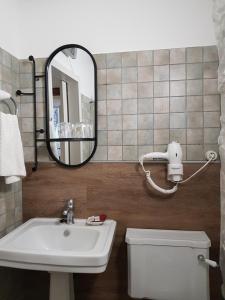 La salle de bains est pourvue d'un lavabo et d'un miroir. dans l'établissement Pensión con Encanto San Martiño Pinario, à Saint-Jacques-de-Compostelle