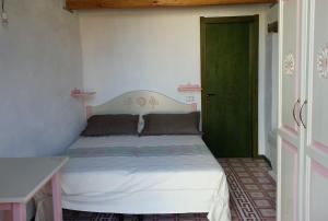 a bedroom with a bed with a green door at Sa Domu e Crakeras in Oristano
