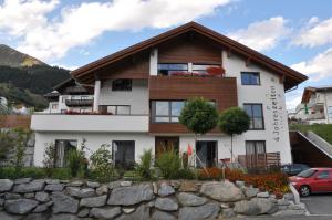 a house with a stone wall in front of it at 4 Jahreszeiten in Fiss