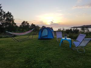 a tent and two chairs and a table and a tent at Leite Telt Camping in Lyngstad