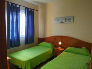 バジェ・グラン・レイにあるCasa Gloriaのベッドルーム1室(緑色のベッド2台、窓付)