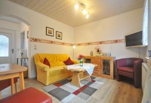 - un salon avec un canapé jaune et une table dans l'établissement Ferienwohnung Adermann Moritzdorf, à Sellin