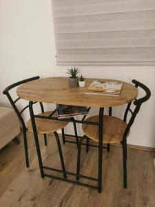 einen Holztisch und einen Stuhl mit einem Tisch und einem Tisch in der Unterkunft Apartman Centar in Aleksandrovac