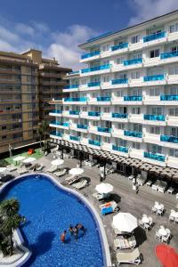 un hotel con piscina frente a un edificio en Aparthotel Acuazul en Peñíscola