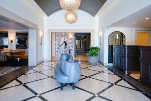 a lobby with a blue chair on a tiled floor at Hotel Amarano Burbank-Hollywood in Burbank