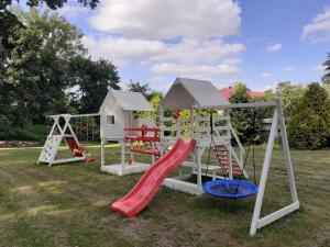um parque infantil com escorrega e uma casa de brincar em Pałac w Krzelowie em Krzelów