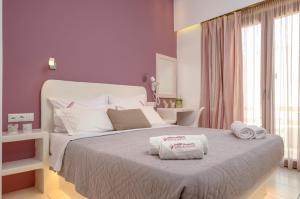 a bedroom with a bed with two towels on it at Panormos Hotel and Studios in Naxos Chora