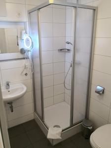 ein Bad mit einer Dusche, einem WC und einem Waschbecken in der Unterkunft Gästehaus und Fewo Lamm Garni in Blaubeuren