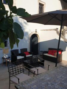 a patio with tables and chairs and an umbrella at Mansion Art House 1800 in Tribalj
