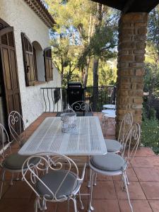 een witte tafel en stoelen op een patio bij Villa provençale – grand jardin - 2 chambres in Bandol