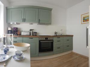 a kitchen with green cabinets and a counter top at Zum Bachhexje in Alken