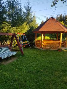 um parque infantil com um gazebo e um baloiço em Pensiunea Nadine em Agapia