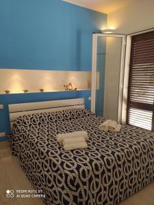 サン・ヴィート・ロ・カーポにあるCasa Vacanze Controventoのベッドルーム1室(ベッド1台、タオル2枚付)