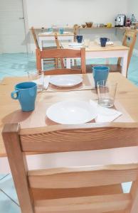 a wooden table with plates and glasses on it at Pepi B&B in Santa Maria di Castellabate