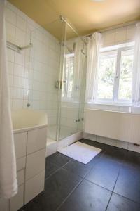 een badkamer met een douche en een bad en een raam bij Haus Hirt - Idyllisch wohnen zwischen Augsburg und München in Klosterlechfeld