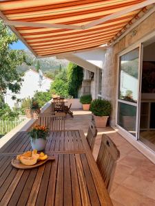 a wooden table with a plate of fruit on a patio at City apartments Bobic in Cavtat