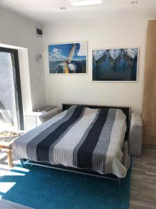 a bedroom with a bed and two pictures on the wall at Széplak No.1. in Siófok