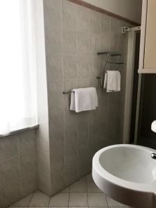 ein Badezimmer mit einer Badewanne, einem Waschbecken und Handtüchern in der Unterkunft Affittacamere Monica in Levanto
