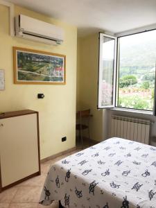 een slaapkamer met een bed en een raam bij Affittacamere Monica in Levanto