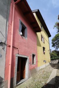 um edifício vermelho com um buraco no lado em La casa del Mamao em Mergozzo