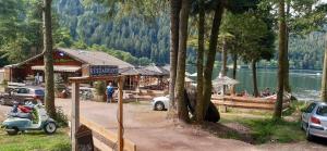 um edifício com uma scooter estacionada ao lado de um lago em La Perle au bord de la rivière em Gérardmer