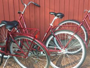 duas bicicletas vermelhas estacionadas ao lado de uma parede vermelha em Hotell Gullvivan em Brändö