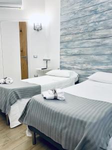 una camera con due letti e asciugamani di MAISON MARIANNA B&B - ETNA - a Nicolosi