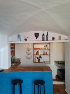 カセレスにあるCasas de la Judería, judería viejaのキッチン(青いカウンター、スツール付)