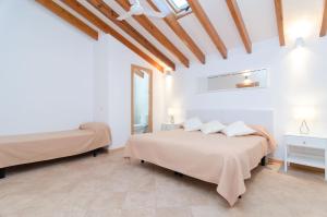 a bedroom with two beds and a ceiling with beams at Embat - alberg juvenil in Montuiri