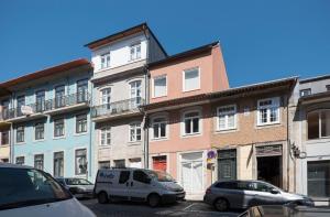 un grupo de coches estacionados frente a los edificios en Heart of D Pedro Apartments, en Oporto