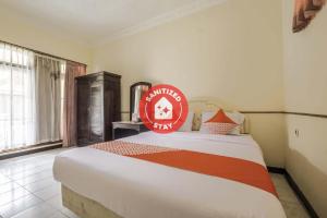 a bedroom with a bed with a red sign on it at Super OYO 2346 Hotel Padjadjaran 1 in Tasikmalaya