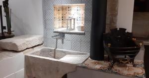 a bathroom with a stone sink and a chair at Via Pezza 100 in Ragusa