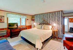 a bedroom with a bed and a flat screen tv at Timberholm Inn in Stowe