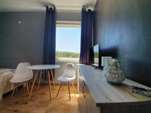 a room with a table and chairs and a window at Hostel AgMa in Jasień